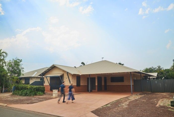 two people walking towards a house