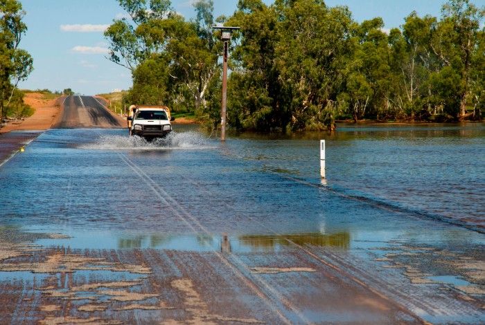 Ute driving through a flooded road 