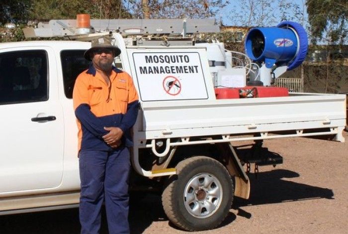 City of Karratha Tradesman standing in front of a "Mosquito Management" road sign