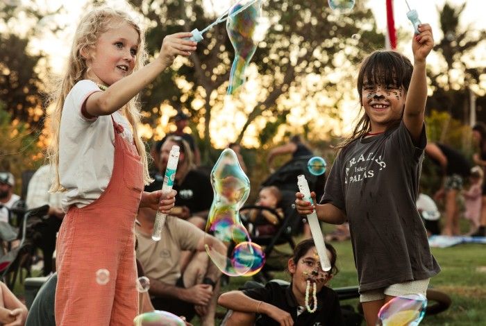 Two children playing with bubbles